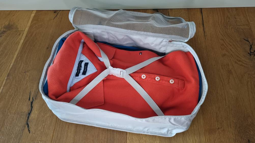 Ein rotes Hemd in einem Packwürfel. 