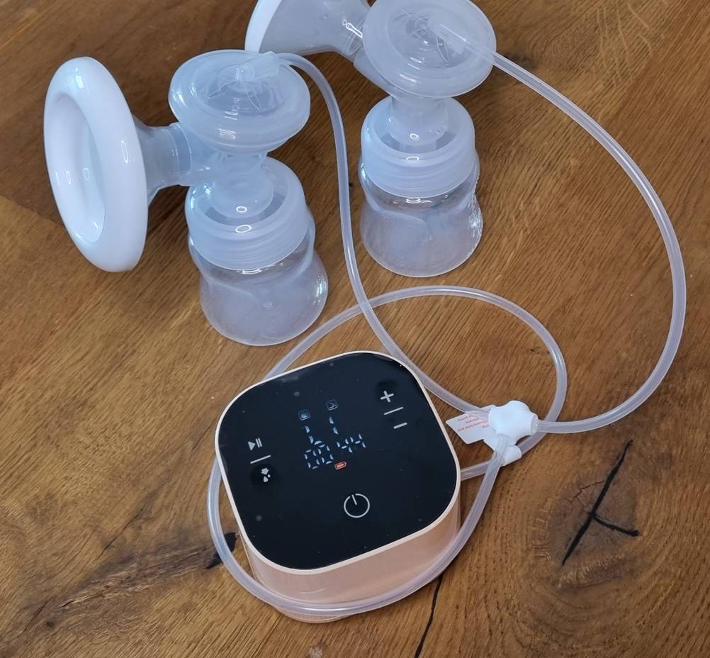 Das Display einer elektrischen Milchpumpe und zwei angeschlossene Fläschchen. 