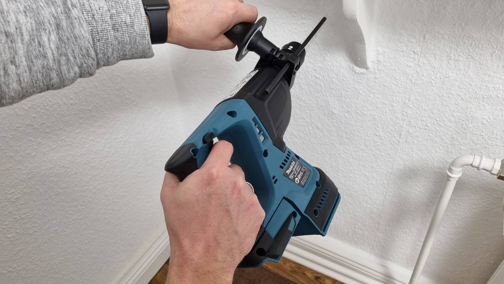 Ein blauer Akku Bohrer im Einsatz an einer Wand.
