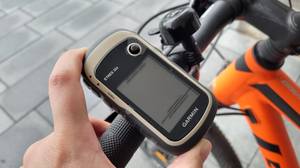 Ein Fahrrad-Navi wird an einem Lenker befestigt.