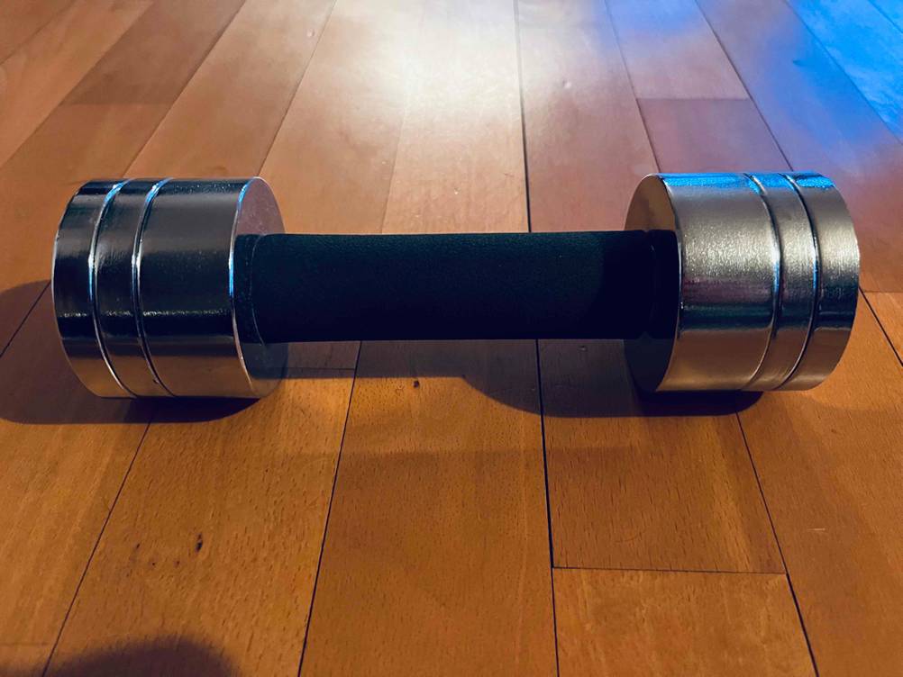 Eine getestete Hanteln 1 kg horizontal auf einem Holzboden.