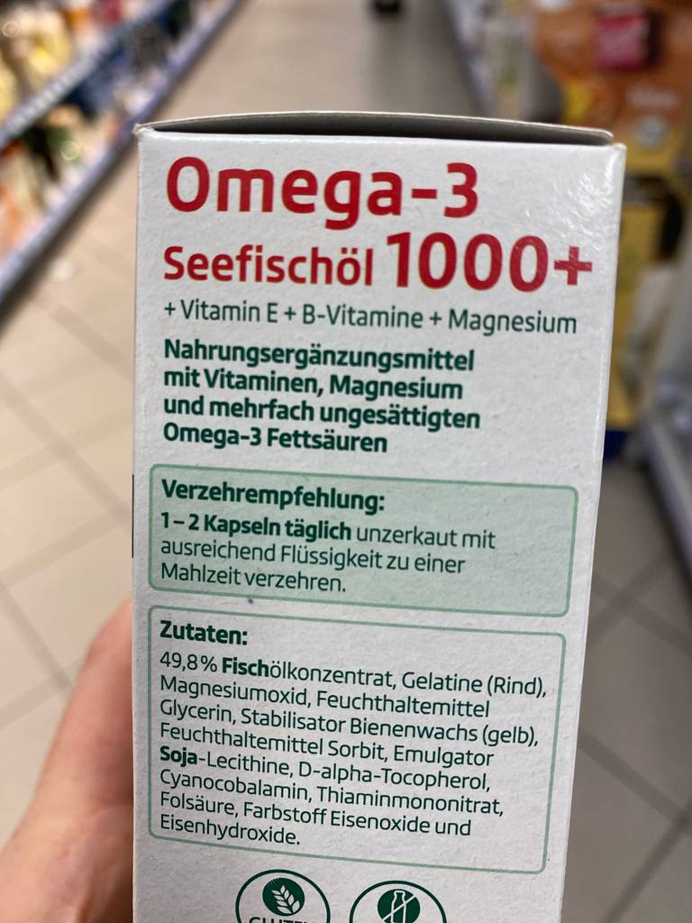 Omega-3-Öl getestet: die Verpackung eines Omega-3-Öls wird in der Hand gehalten, mit Blick auf die Verzehrempfehlung.