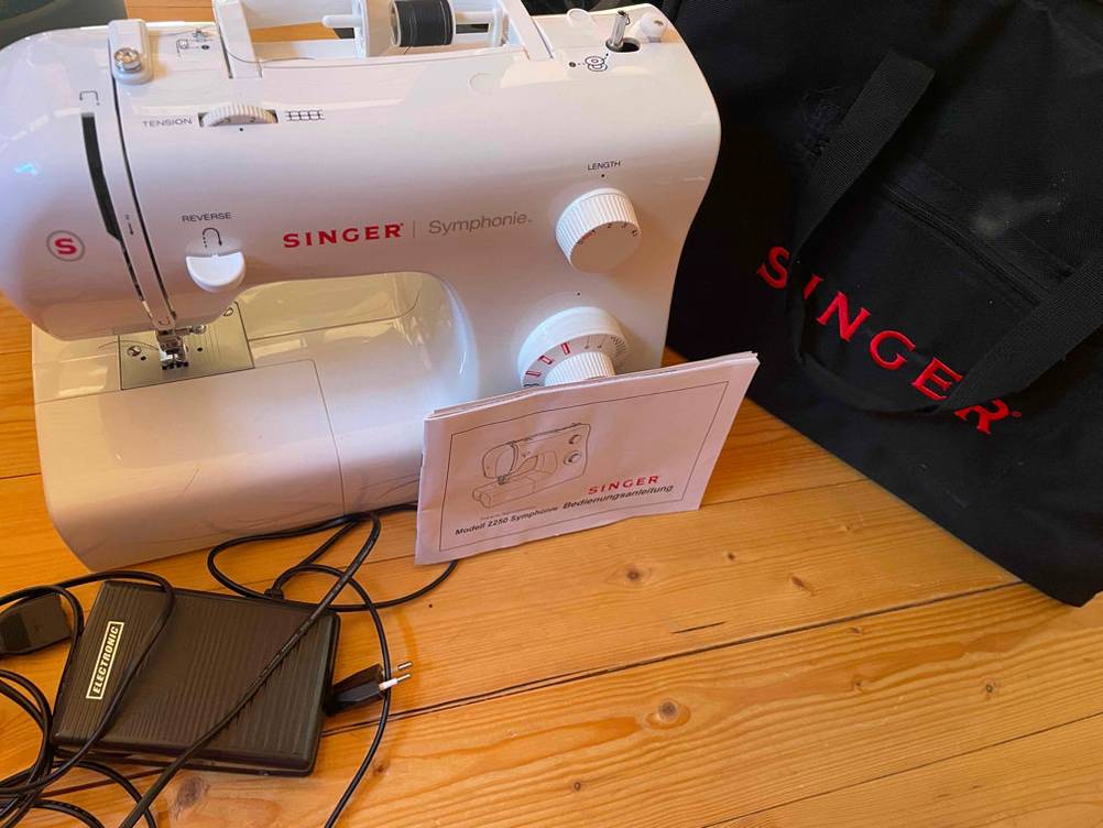 Im Test: Singer Nähmaschine mit Zubehör steht auf einem Holzboden.