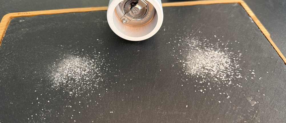 Gemahlenes Salz liegt neben der Salzmühle vom Peugeot 2/24277 Tahiti Duo.