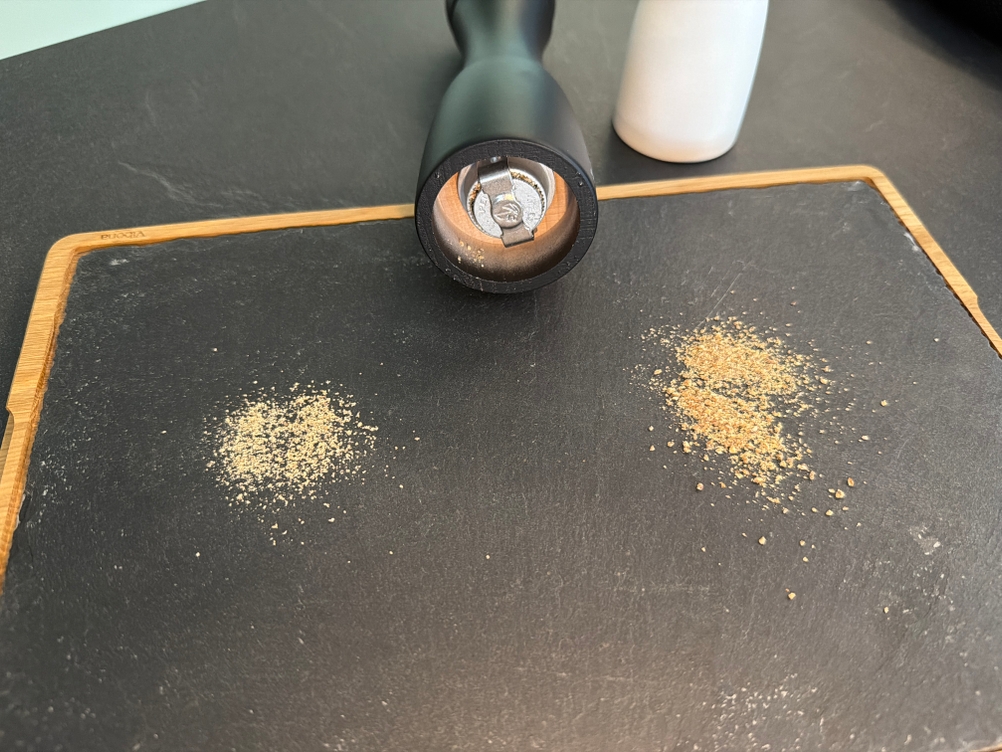 Gemahlener Pfeffer liegt neben der Pfeffermühle vom Peugeot 2/24277 Tahiti Duo