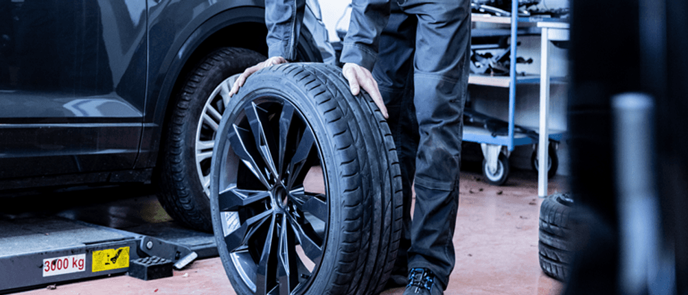 245/40-R19-Winterreifen getestet: Ein Reifen mit Felge wird in einer Werkstatt montiert