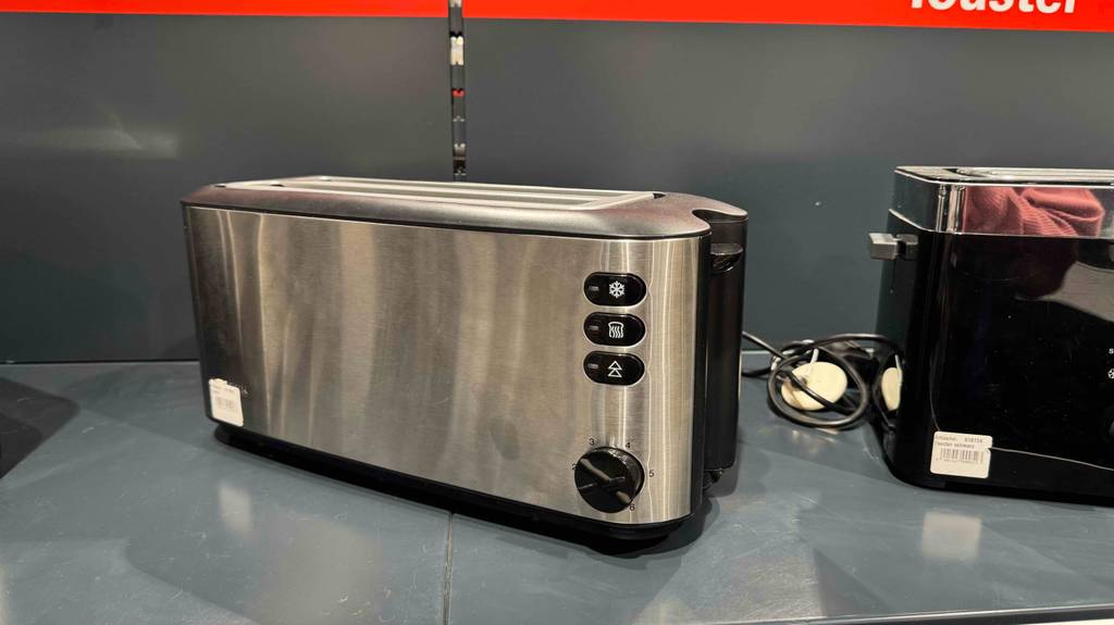Im Test: Der Doppel-Langschlitztoaster aus Edelstahl steht auf einem grauen Regal neben einem schwarzen Toastermodell.