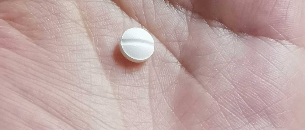 Im Test: In einer Hand liegt eine einzelne Allergietablette.