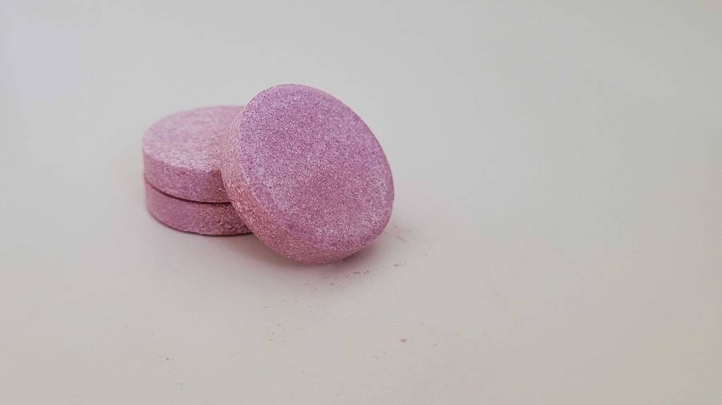 Drei getestete Zink-Tabletten in Nahaufnahme auf einem einen Untergrund platziert.