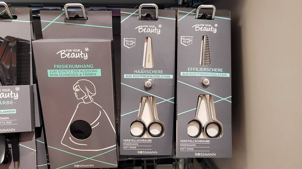 Friseurschere im Test: zwei unterschiedliche Friseurscheren hängen in einem Regal.
