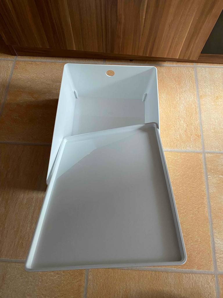 Test: offene weiße Schuhbox mit Deckel darauf liegend.