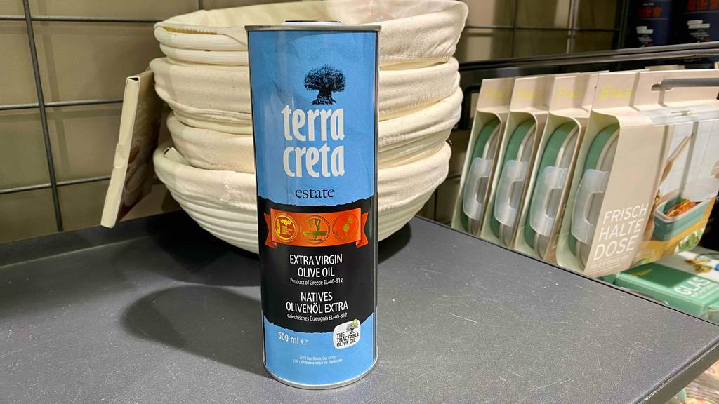 Terra-Creta-Olivenöl im Test: eine Flasche Terra-Creta-Olivenöl stehend vor Brotkörbe.