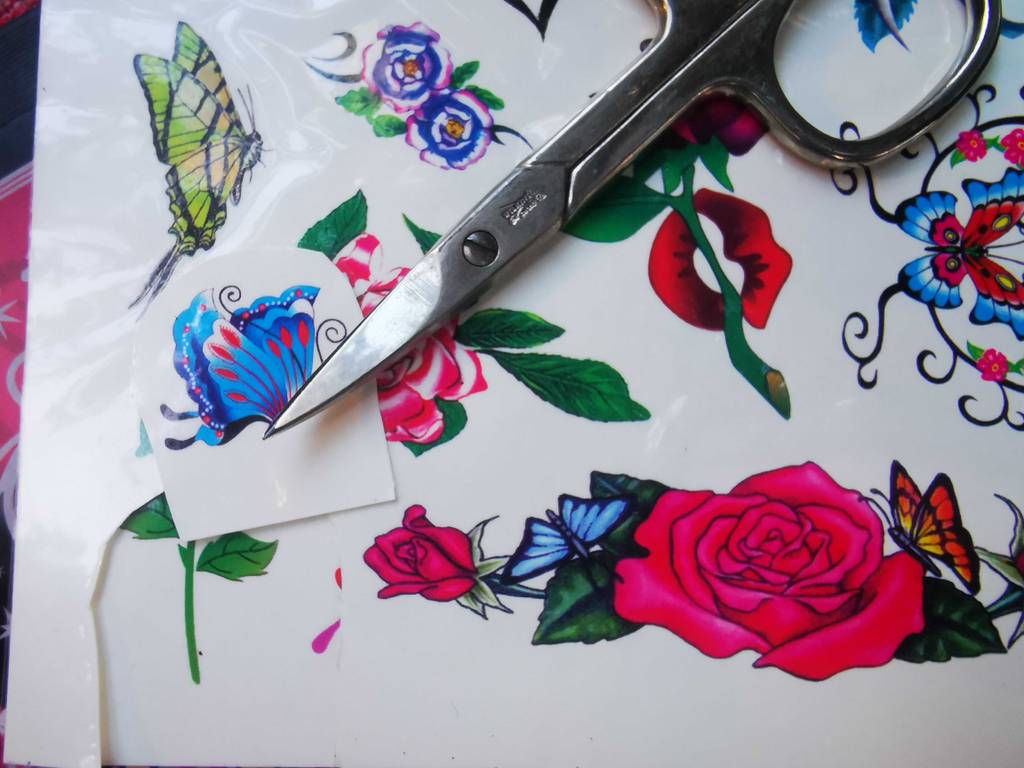 Kindertattoos im Test: Ein ausgeschnittenes Schmetterlingsmotiv liegt unter der Schere.