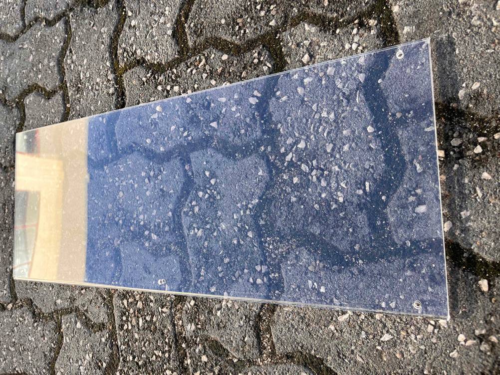 Acrylglas im Test: ein Acrylglas liegend auf einem Steinboden.