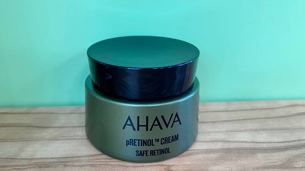 Retinol-Creme im Test: Geschlossene Retinol-Creme vor einer grünen Wand.