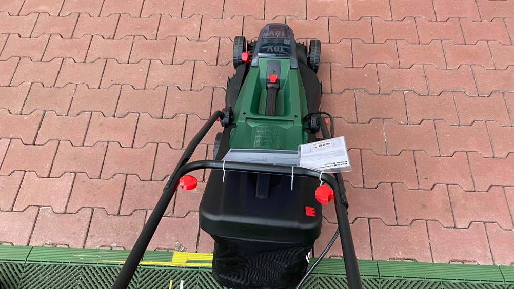Bosch-Akku-Rasenmäher im Test: Rasenmäher von Hinten oben auf Steinboden