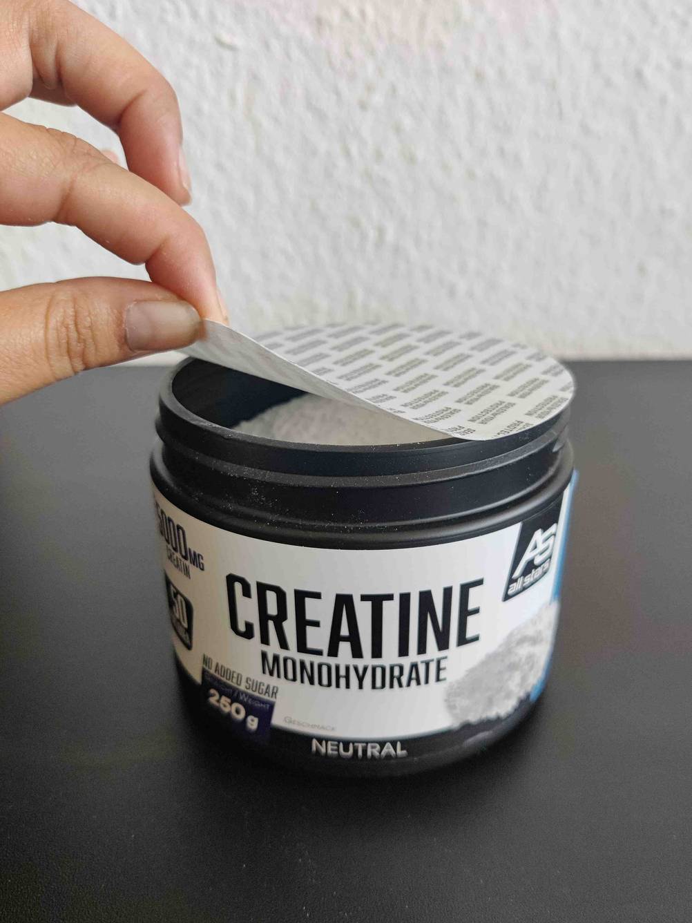 Creatinpulver, dessen Deckel geöffnet wird.