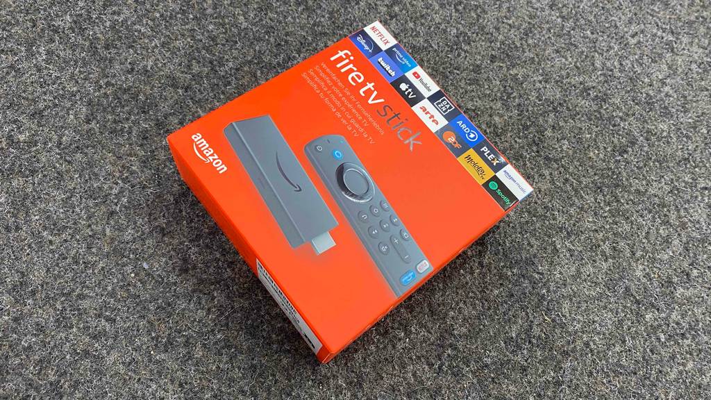 Ein getesteter TV-Stick liegt originalverpackt auf einem grauen Teppich.