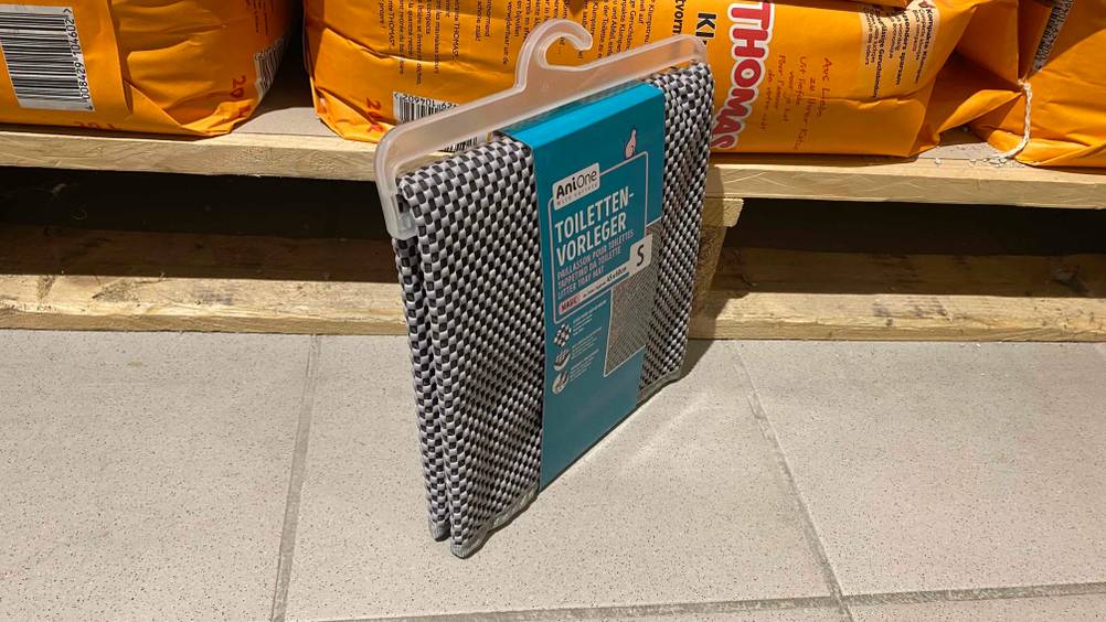 Vor einem Regal steht eine getestete Katzenstreu-Matte auf einem Fließenboden