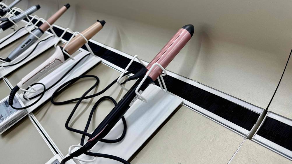 Mehrere Lockenstäbe – darunter auch der getestete BaByliss-Lockenstab werden in einem Geschäft ausgestellt.