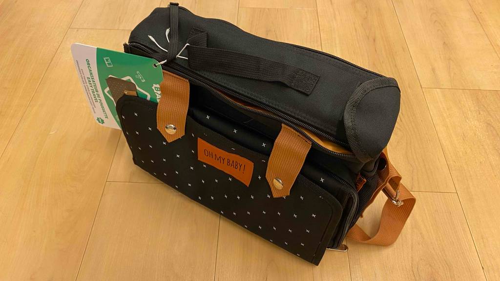 Auf einem Holzboden steht quer ein getesteter Kinderwagen-Organizer