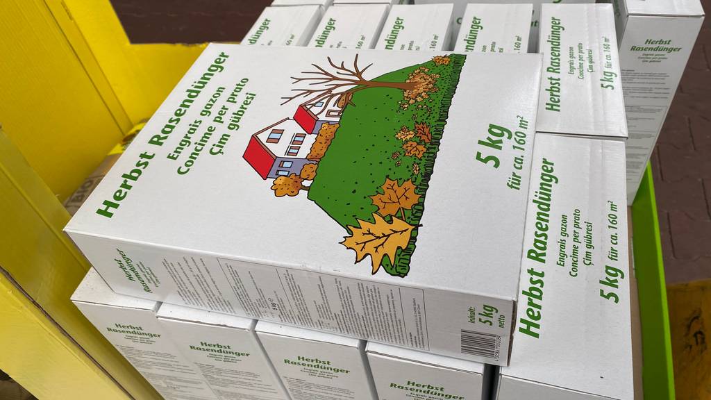 Eine Packung getesteter Herbstrasendünger liegt auf mehreren anderen Packungen horizontal.