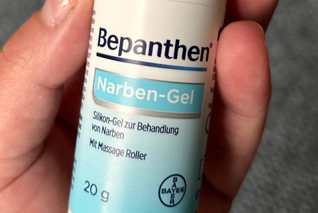 Narbensalbe von Bepanthen in der Hand.