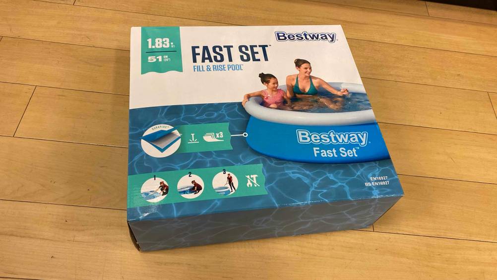 Ein getesteter Pool rund in Originalverpackung auf einem Holzboden.