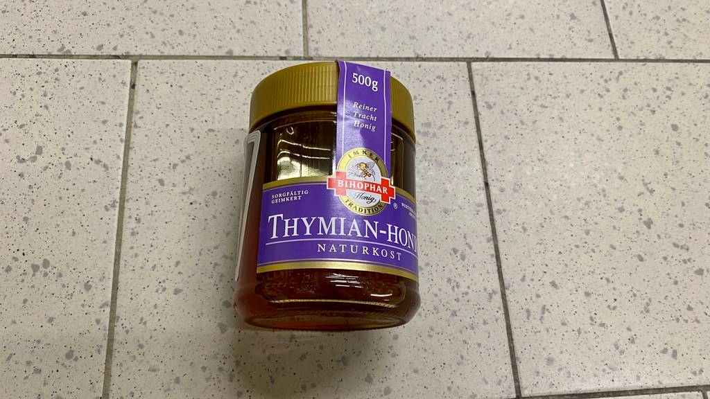 Thymianhonig im Test: Ein Glas liegt auf Fließenboden
