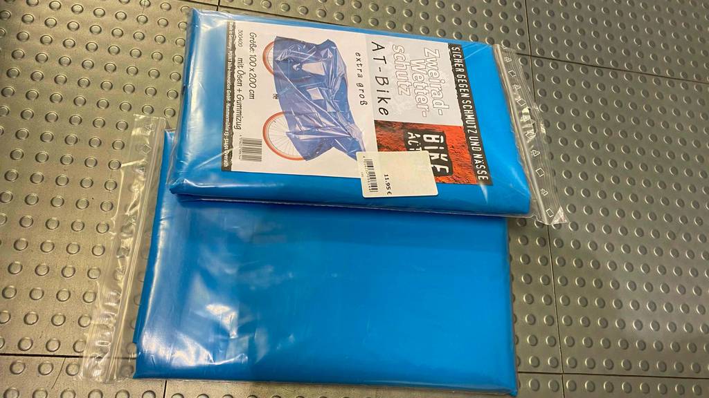 Fahrradschutzhülle-Test: zwei blaue Fahrradschutzhüllen in Verpackung. eine von der Vorder- und eine von der Rückseite ersichtlich.