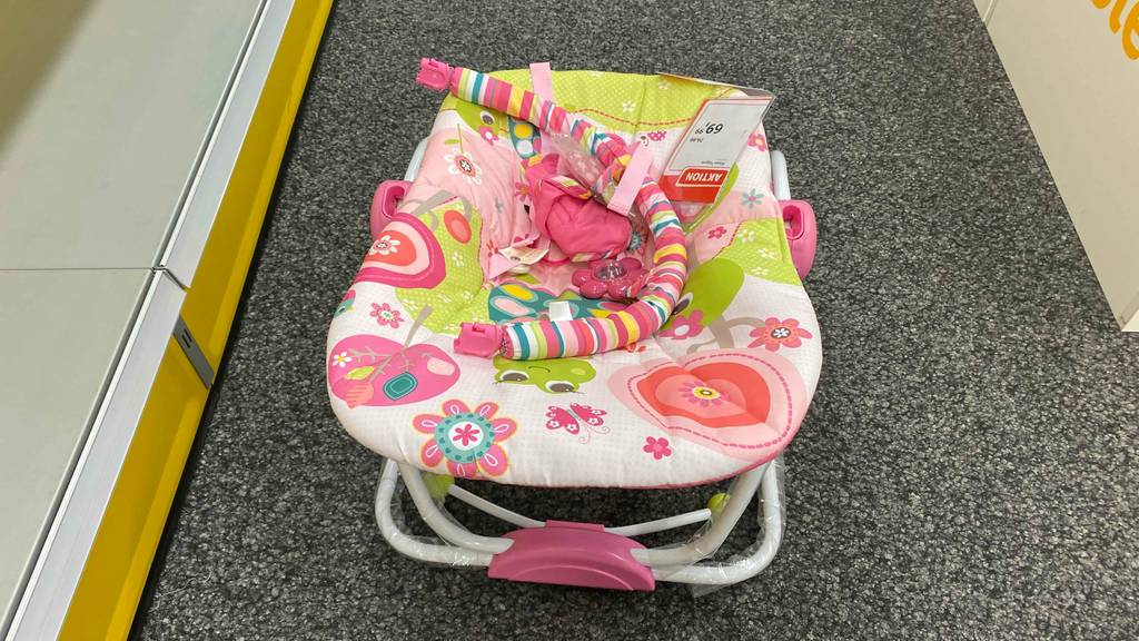 Eine getestete Babywippe bis 18 kg von hinten oben auf einem grauen Teppich stehend.
