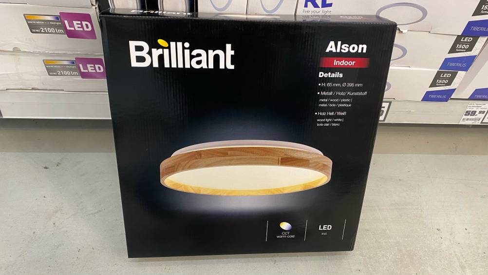 Auf einem hellen Boden steht eine Packung LED-Deckenleuchte von vorne.