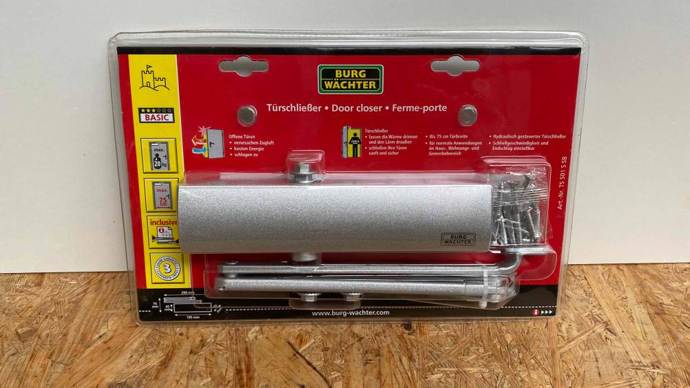 Türschließer-Test: Türschließer der Marke Burg Wächter in Verpackung vor einer weißen Wand gelehnt.