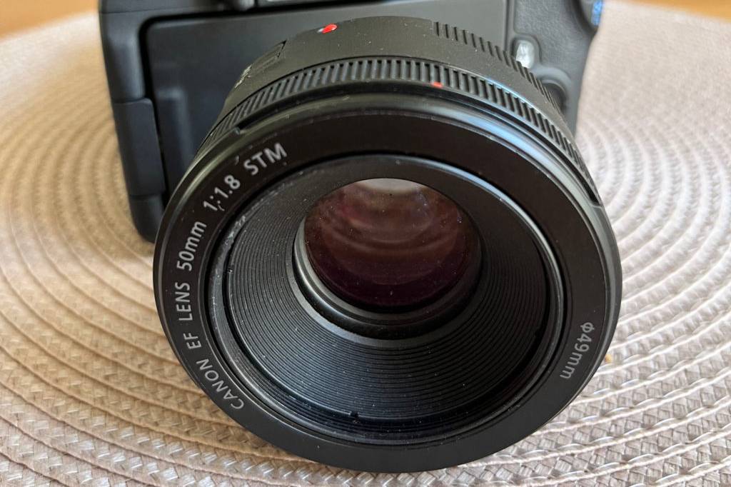 Objektive für Canon im Test: Objektiv vor Kamera auf heller Oberfläche