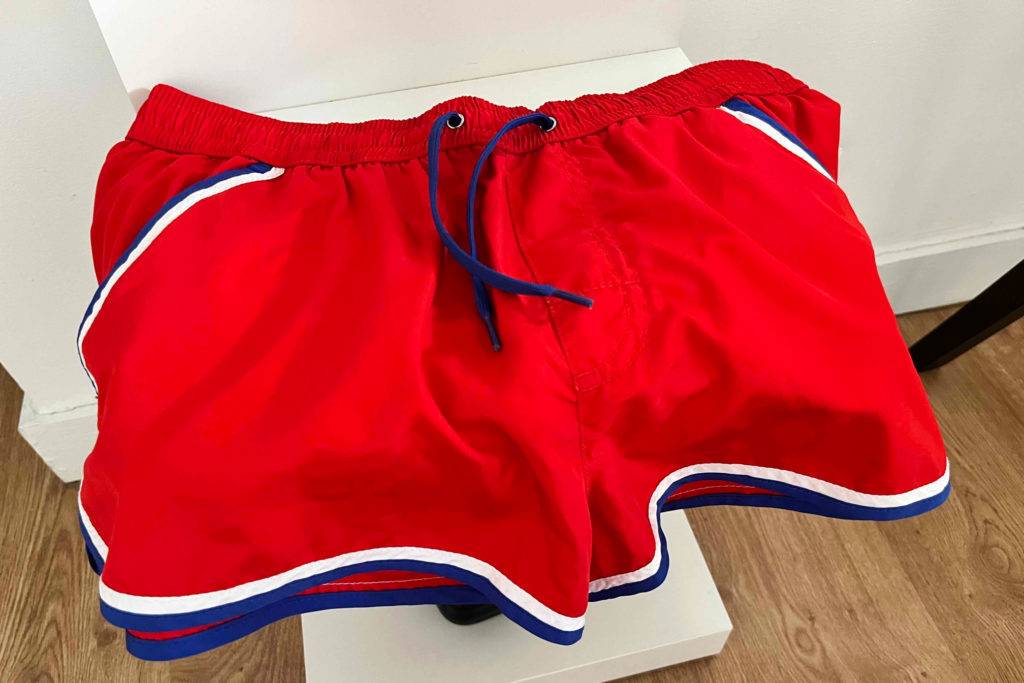 Badehose getestet: Eine rote Badehose liegt über einem weissen Beistelltisch