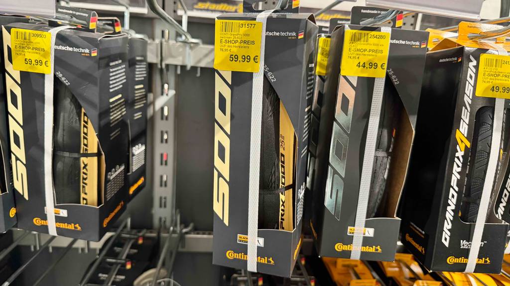 Mehrere Rennrad-Reifen (25-622) im Test hängen in den Verpackungen nebeneinander an einem Verkaufsregal.