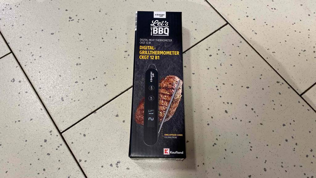 Im Test: Auf einem hellen Boden liegt ein verpacktes Grillthermometer