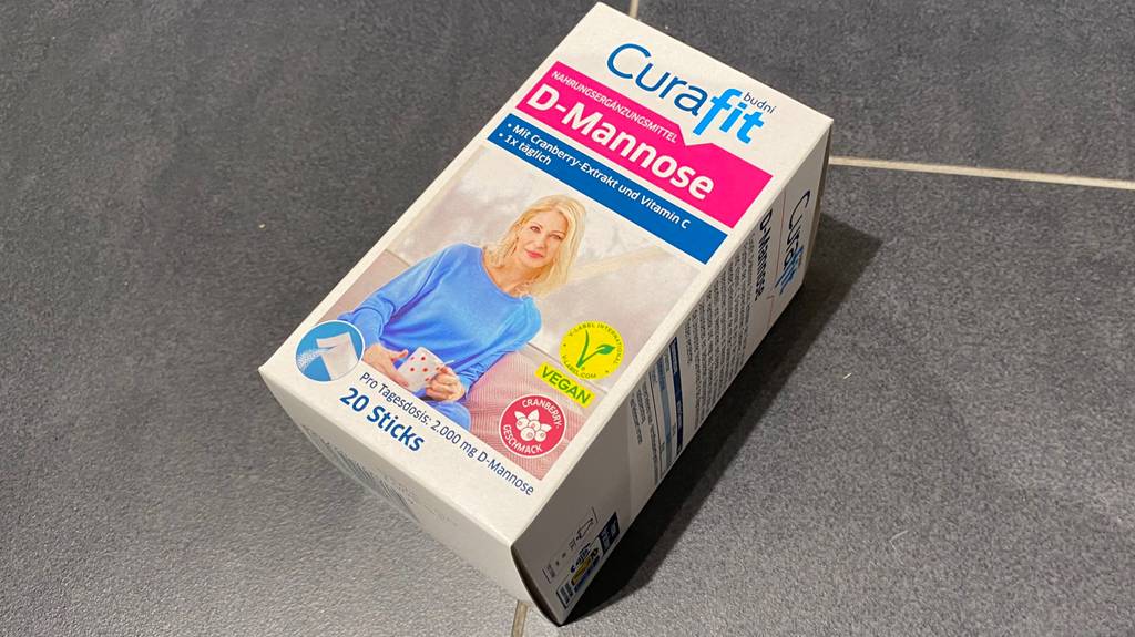 D-Mannose getestet: Auf einem grauen Untergrund liegt eine Packung D-Mannose