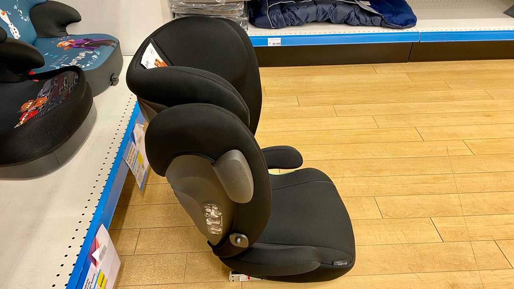 Ein getesteter Cybex Kindersitz von der Seite vor einem Regal auf dem Holzboden stehend.