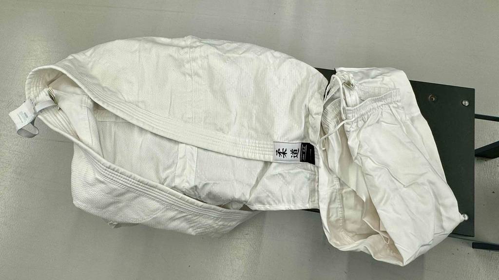 Getestet: der gesamte Judoanzug mit inkl. Hose liegt auf einer schwarzen Sitzbank.