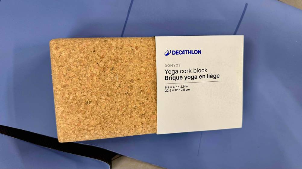 Ein getesteter Yogablock aus Kork liegt auf einem blauen Untergrund.