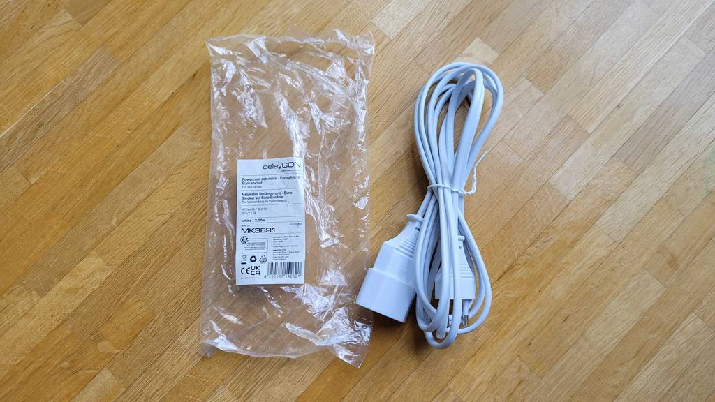 Verlängerungskabel im Test: ein zusammengebundenes Verlängerungskabel neben der Plastikverpackung liegend.