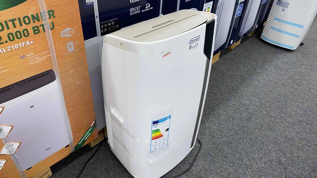 De’Longhi-Klimagerät getestet: weißes De’Longhi-Klimagerät vor Verpackung stehend mit Etikett darauf wo Energieeffizienzklasse ersichtlich ist.