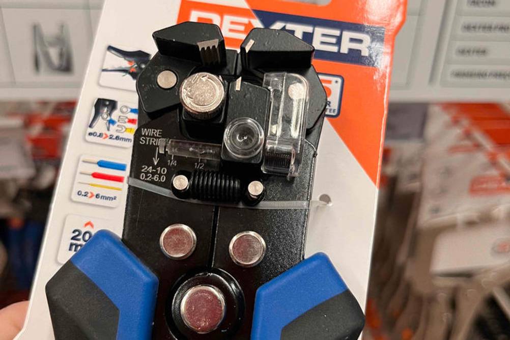 Automatische-Abisolierzange getestet: Abisolierzange ist mit Kabelbinder noch an Verpackung befestigt und wird in der Hand gehalten.