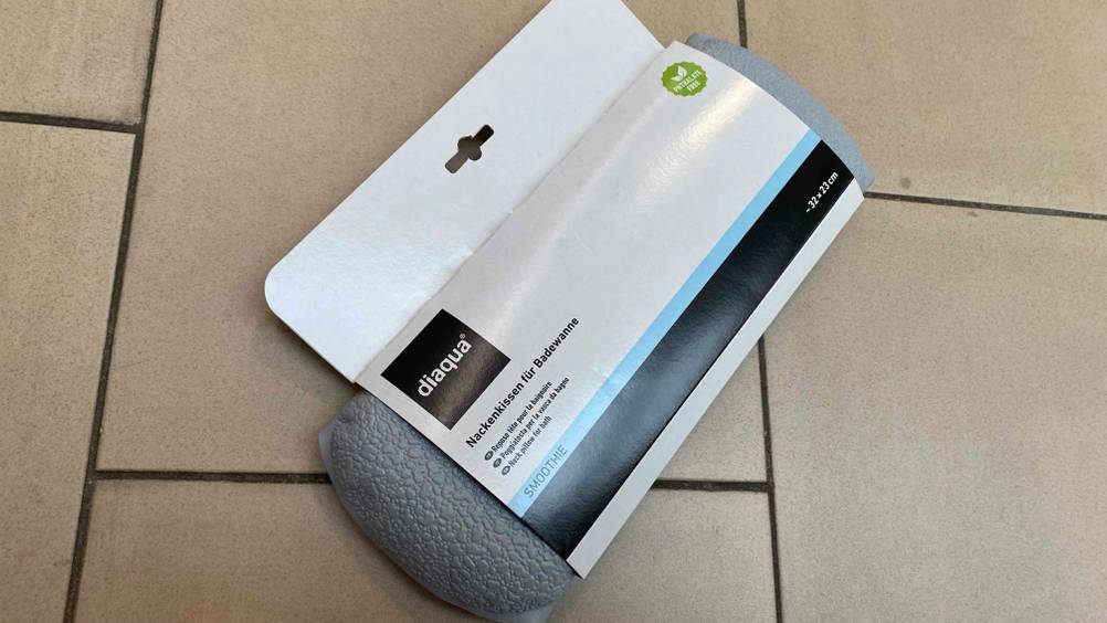 Nackenkissen getestet: Auf einem Fliesenboden liegt ein verpacktes Nackenkissen.