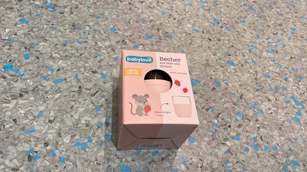 Im Test: Ein Trinklernbecher in Verpackung von oben auf einer grauen Fläche.