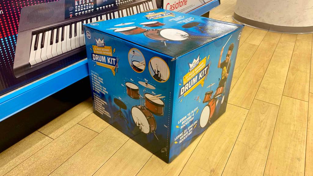 Kinderschlagzeuge getestet: Auf einem Holzboden steht ein Kinderschlagzeug in Verpackung.