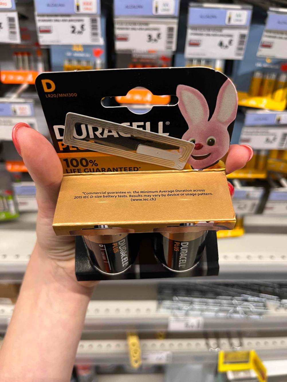 D-Batterien-Test: vor Regal mit vielen Batterien, Duracell-Plus-Doppelpack von oben in einer Hand.