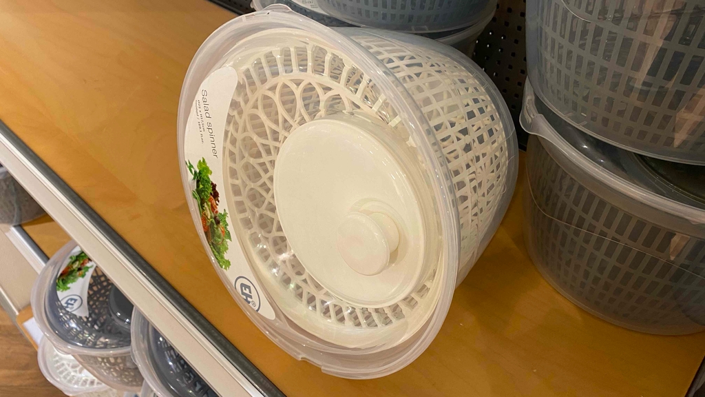 Getestete Salatschleuder liegt auf einer Holzfläche.