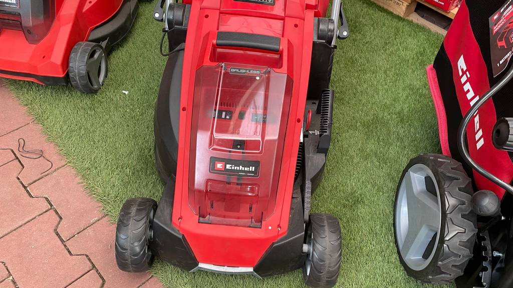 Einhell-Rasenmäher-Test: roter Einhell-Rasenmäher steht auf einem Kunstrasen.